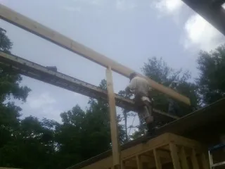 Carpenter setting a ridge beam over a new addition frame — Ice Dam Removal by Roofing Brothers in Monroe Bridge