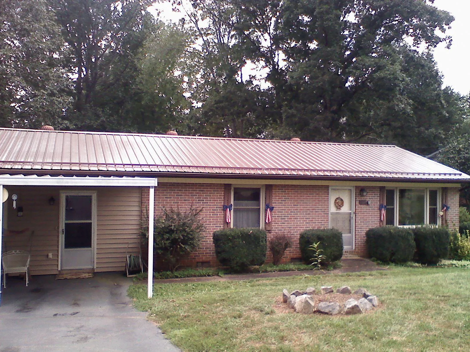 Bronze metal roof and carport on a brick ranch home — Roof Repair work by our crew in Monroe Bridge